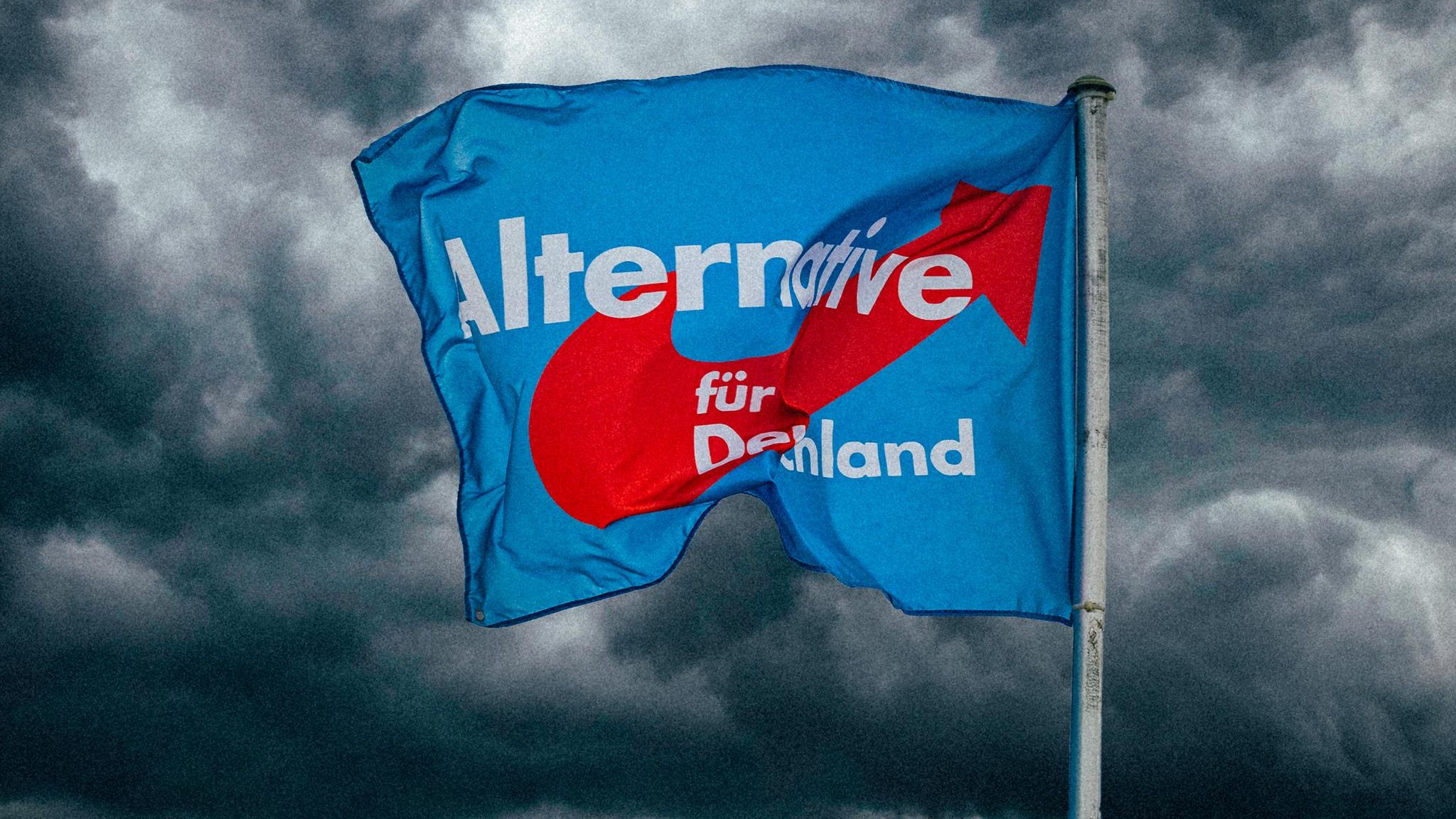 Eine AfD-Fahne vor dunklen Wolken
