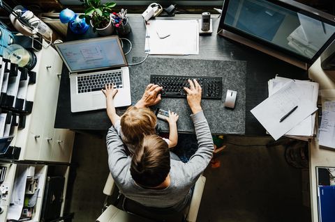 Arbeitszeitgesetz: Mann sitzt mit Kind auf dem Schoß im Homeoffice