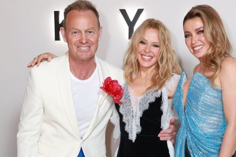 Kylie Minogue (M.) mit Ex-Freund Jason Donovan und Schwester Dannii posieren bei der Doku-Premiere in London.