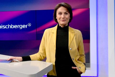 Sandra Maischberger steht im TV-Studio und blickt in die Kamera
