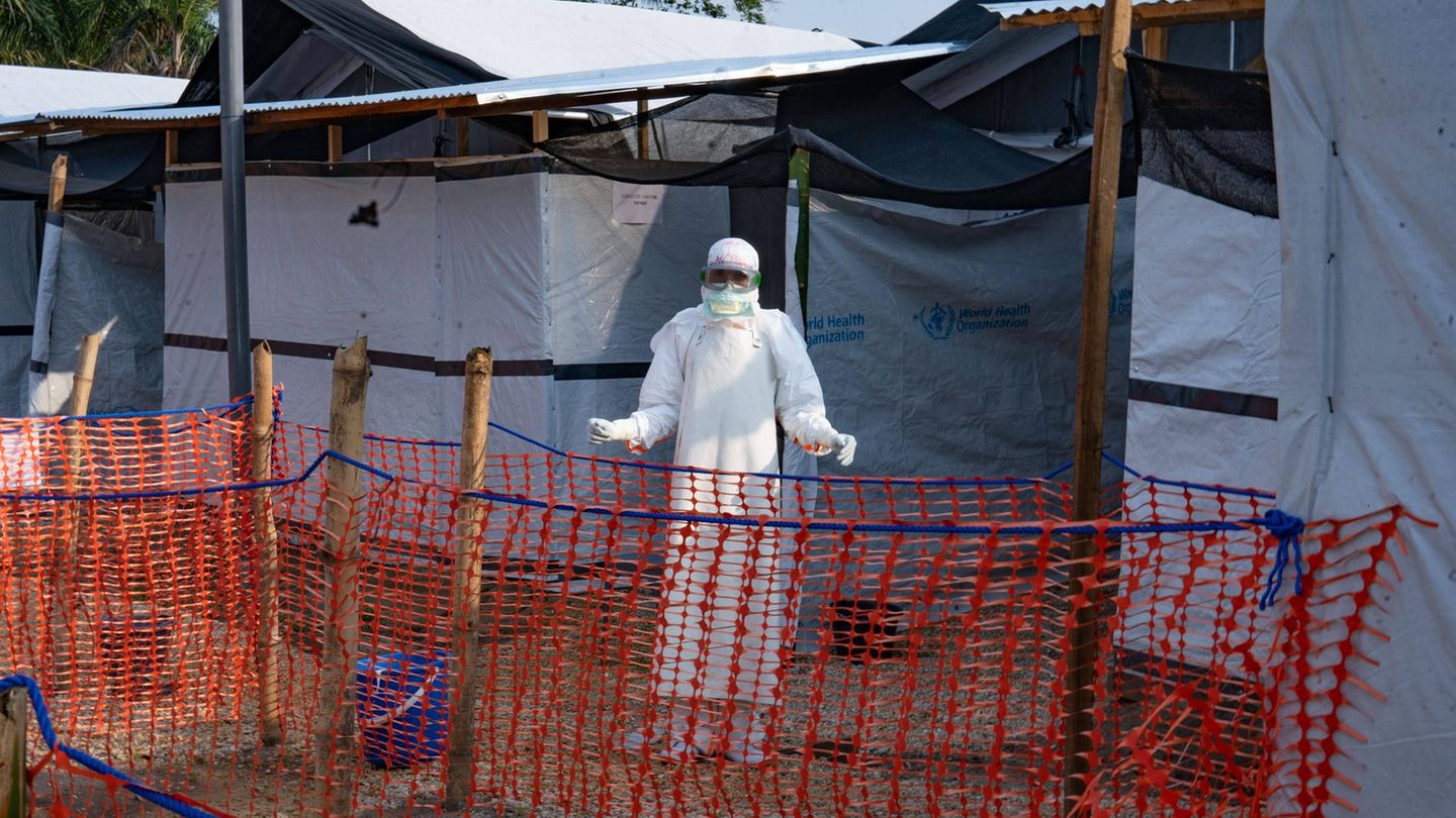 Ein Mensch im weißen Anzug steht vor einem Ebola-Behandlungszentrum im Kongo