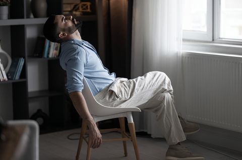 Ein Mann wartet alleine in seinem Zimmer auf die RTückkehr seiner Fernbeziehung