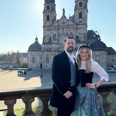 Das Hessentagspaar 2026, Max und Vera Dudyka, posiert in seiner Heimatstadt Fulda vor dem Dom. (Archivbild) Foto: Michael Bauer/