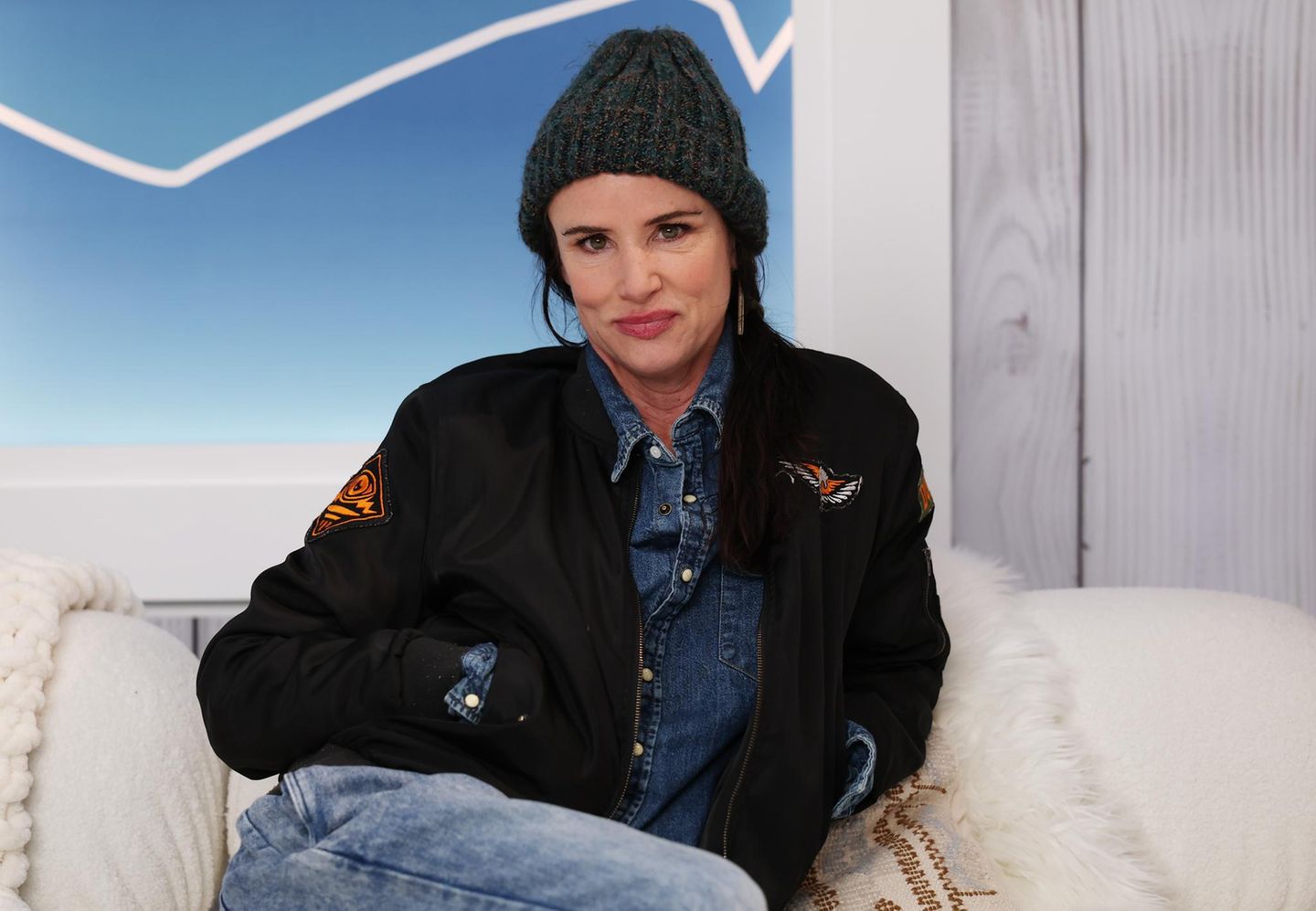 Juliette Lewis sitzt auf einem Sofa und blickt in die Kamera