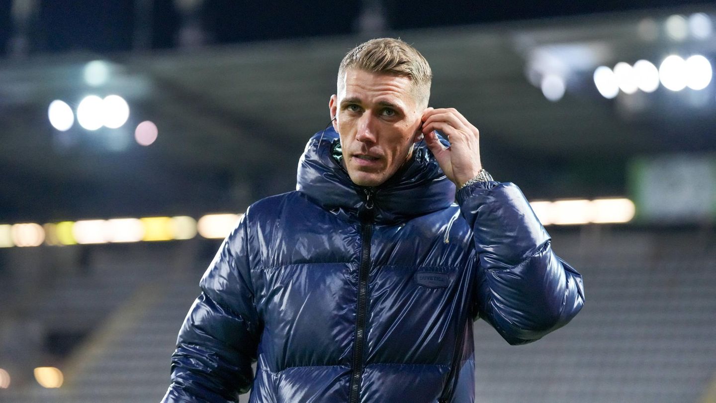 Nils Petersen steckt sich einen Kopfhörer ins Ohr