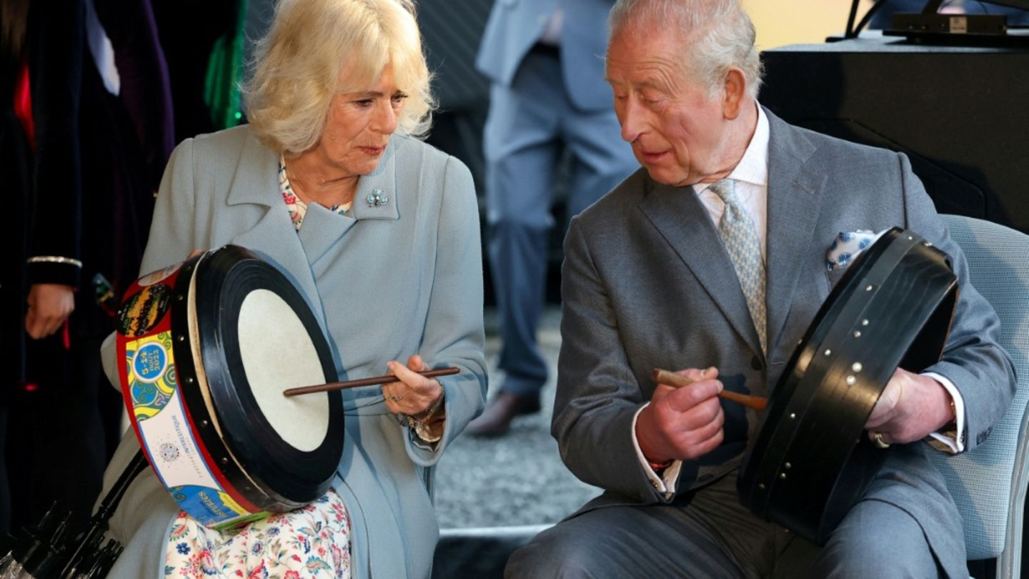 Charles und Camilla probieren traditionelle Instrumente aus