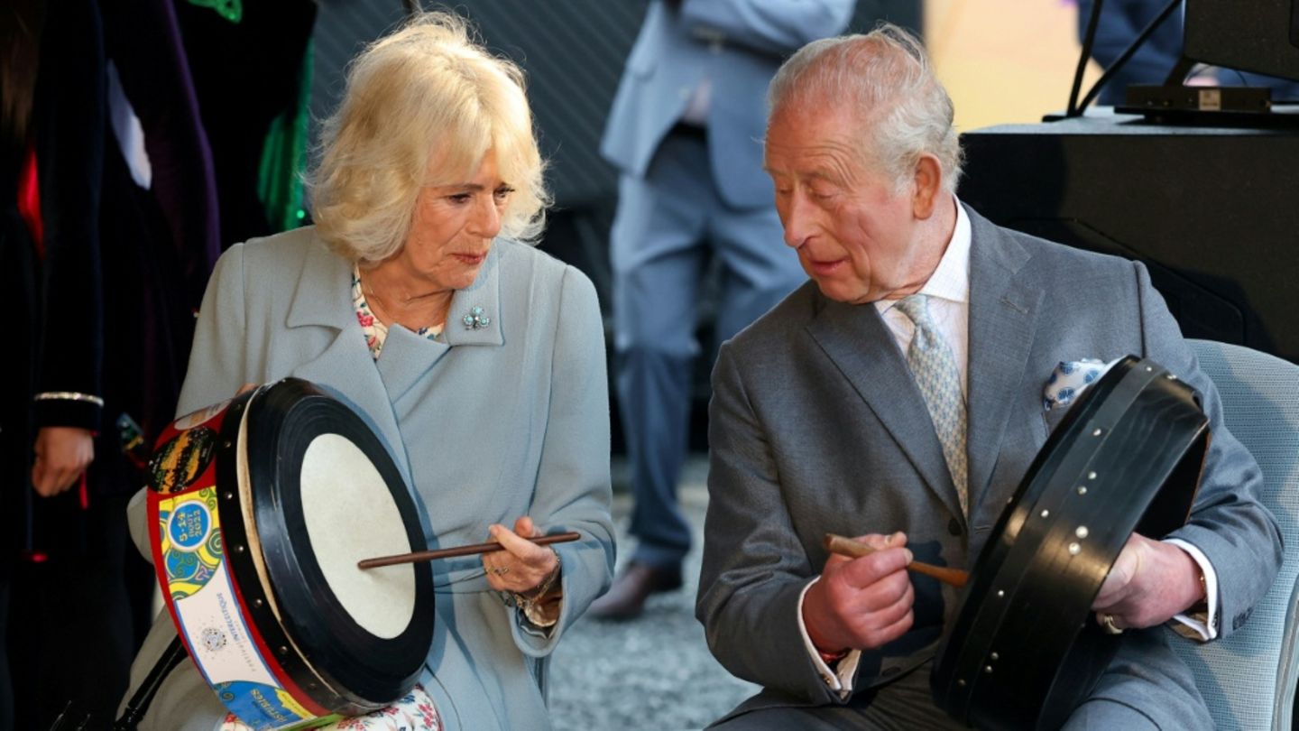 König Charles und Camilla probieren traditionelle Instrumente aus