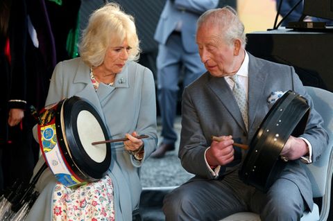 Charles und Camilla probieren traditionelle Instrumente aus