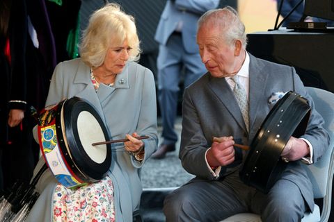 König Charles und Camilla probieren traditionelle Instrumente aus