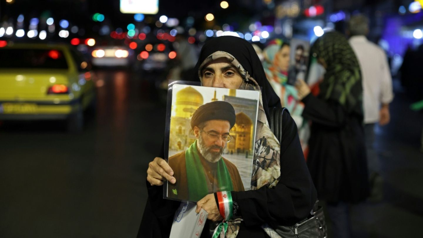 Frau mit Chamenei-Portrait in Teheran