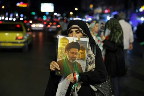 Frau mit Chamenei-Portrait in Teheran