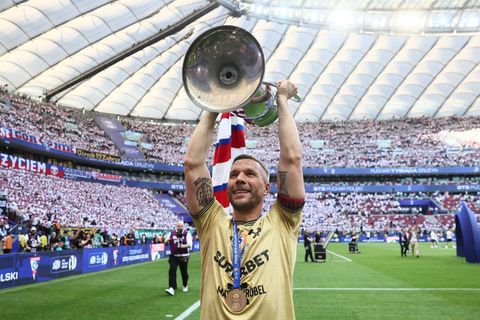 Lukas Podolski jubelt mit der Trophäe nach dem Sieg