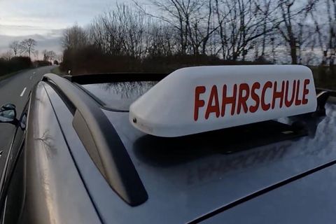 Ein Fahrschulauto fährt auf der Straße.