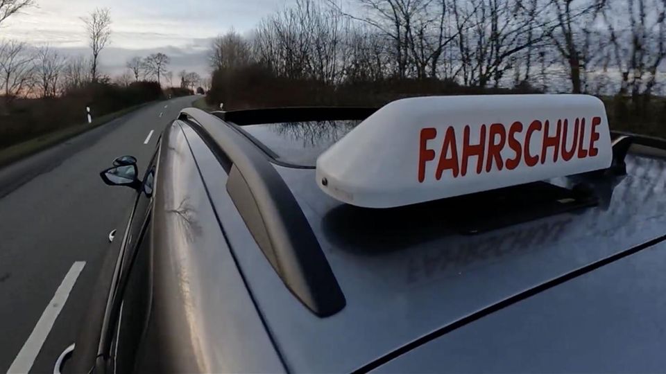 Ein Fahrschulauto fährt auf der Straße.
