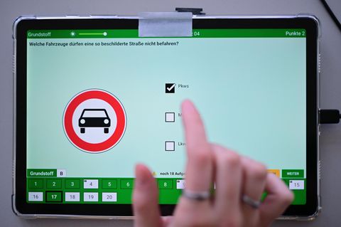 Eine Frau beantwortet eine Frage der theoretischen Prüfung des Führerscheins