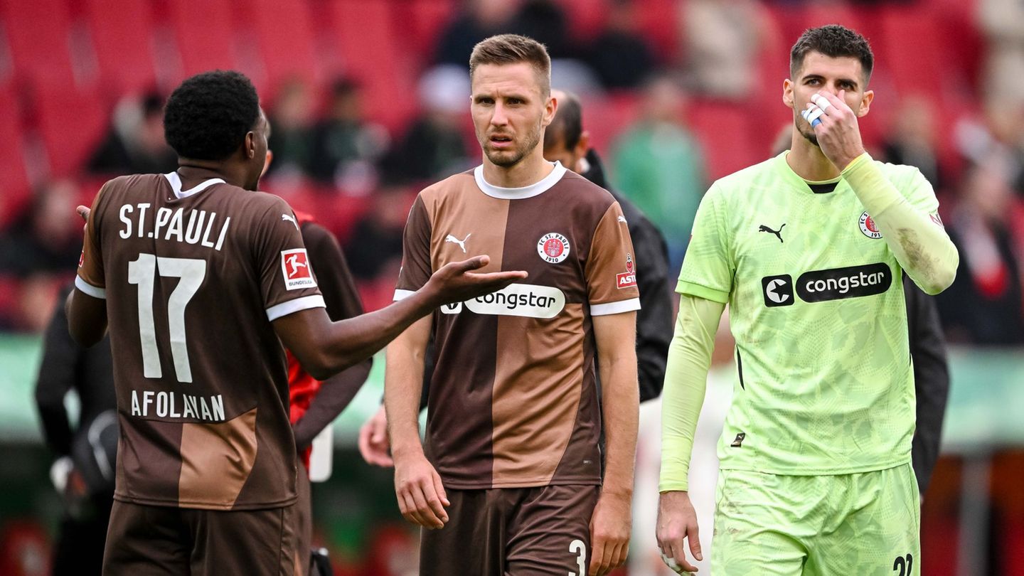 St. Paulis Karol Mets (M) und Torwart Nikola Vasilj (r) verlassen den Club im Sommer. (Archivbild) Foto: Harry Langer/dpa