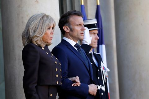 Brigitte Macron steht neben ihrem Mann