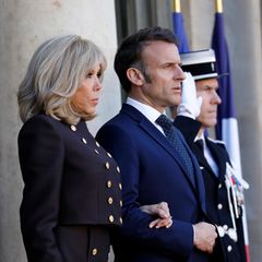 Brigitte Macron steht neben ihrem Mann