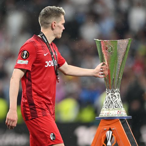 Matthias Ginter vom SC Freiburg berührt im Vorbeigehen den Pokal der Europa League