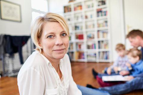 Reich in Rente mit 40: Frau mit Familie im Hintergrund