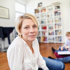 Reich in Rente mit 40: Frau mit Familie im Hintergrund