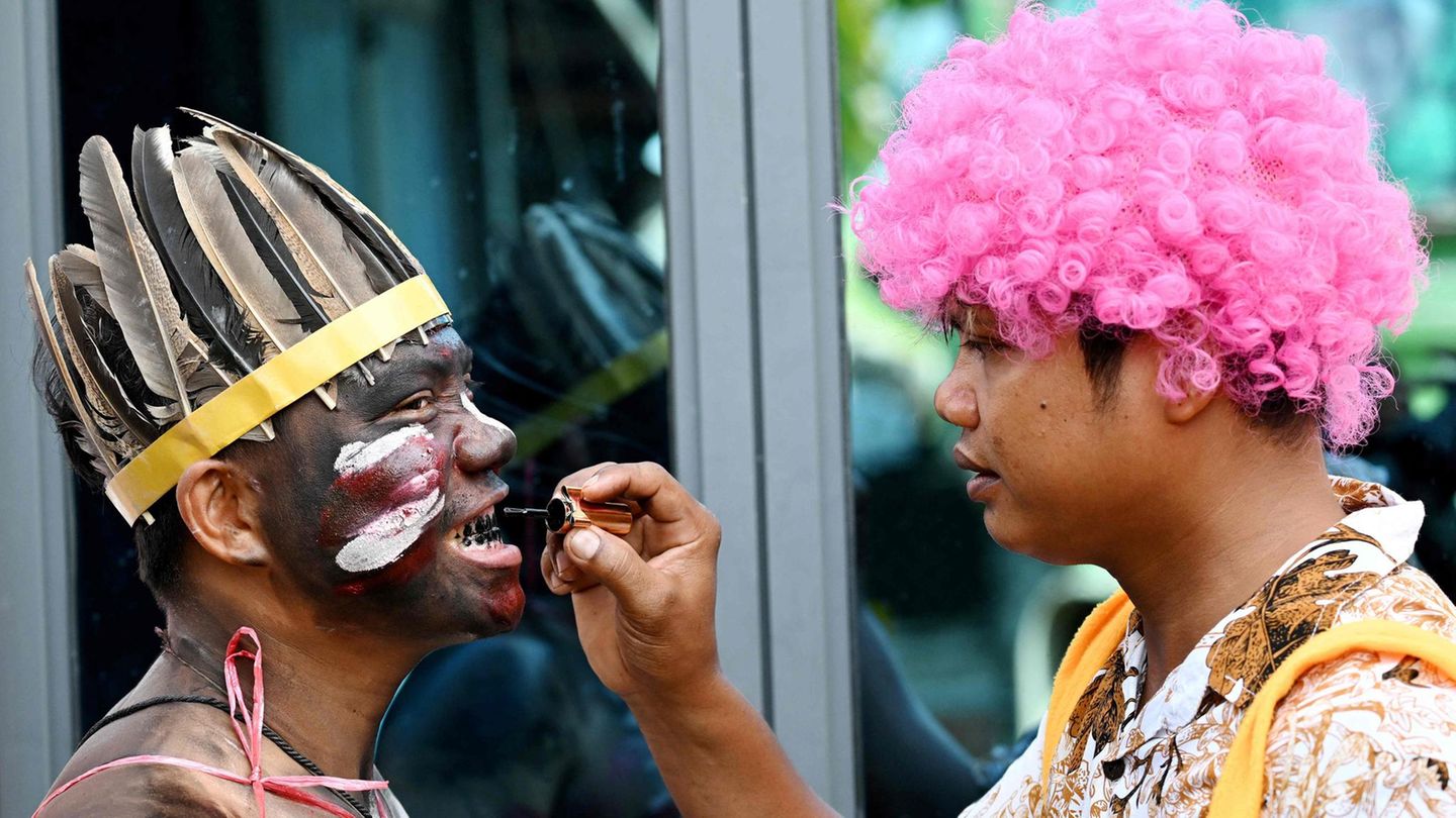 Phnom Penh, Vietnam. Vor dem jährlichen „Pring Ka-Ek“-Fest – auch „Geisterhausfest“ genannt – malt ein Feiernder einem anderen das Gesicht an und sogar die Zähne schwarz. Ob das beim Beten für Glück und Regen hilft? Gruselig dürfte es am Ende jedenfalls aussehen.
