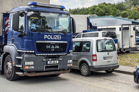 Fahrzeuge der Bundespolizei stehen auf einer Straße in Ahlen. Ermittler aus mehreren europäischen Ländern haben Objekte im Münst