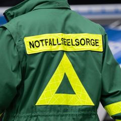 Auf dem Rücken einer grünen Jacke steht schwarz auf gelb "Notfallseelsorge"