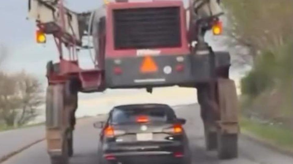 Auto fährt durch Landmaschine hindurch