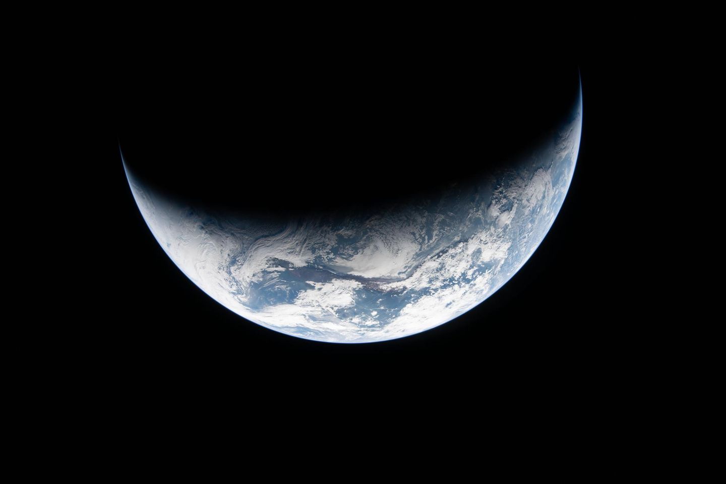 Die Erde als Sichel im Weltraum