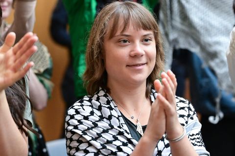 Die Klimaaktivistin Greta Thunberg klatscht als Zuschauerin in einem Gerichtssaal in Stuttgart-Stammheim. Foto: Bernd Weißbrod/d