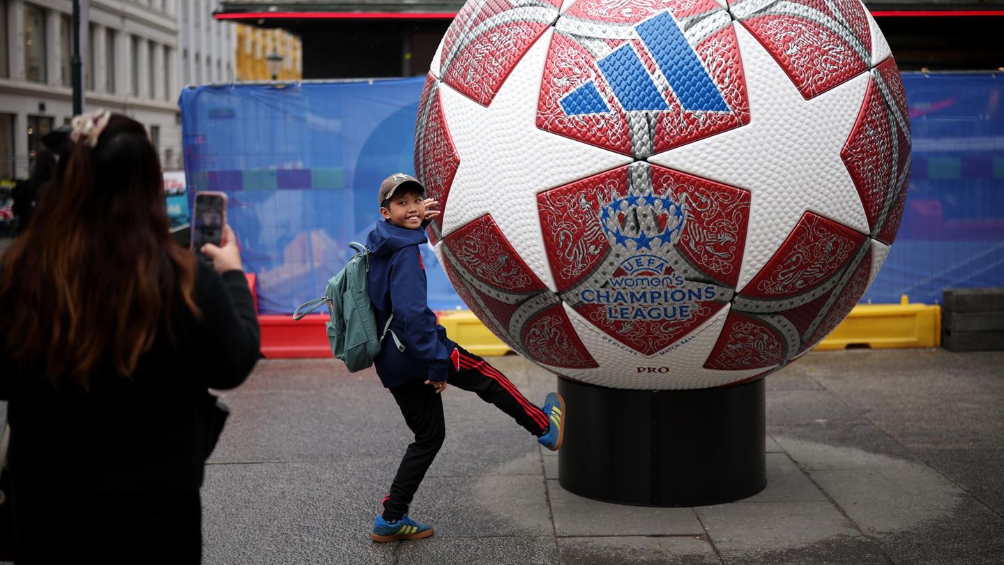 EIn Junge posiert vor einem übergroßen Fußball