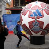 EIn Junge posiert vor einem übergroßen Fußball