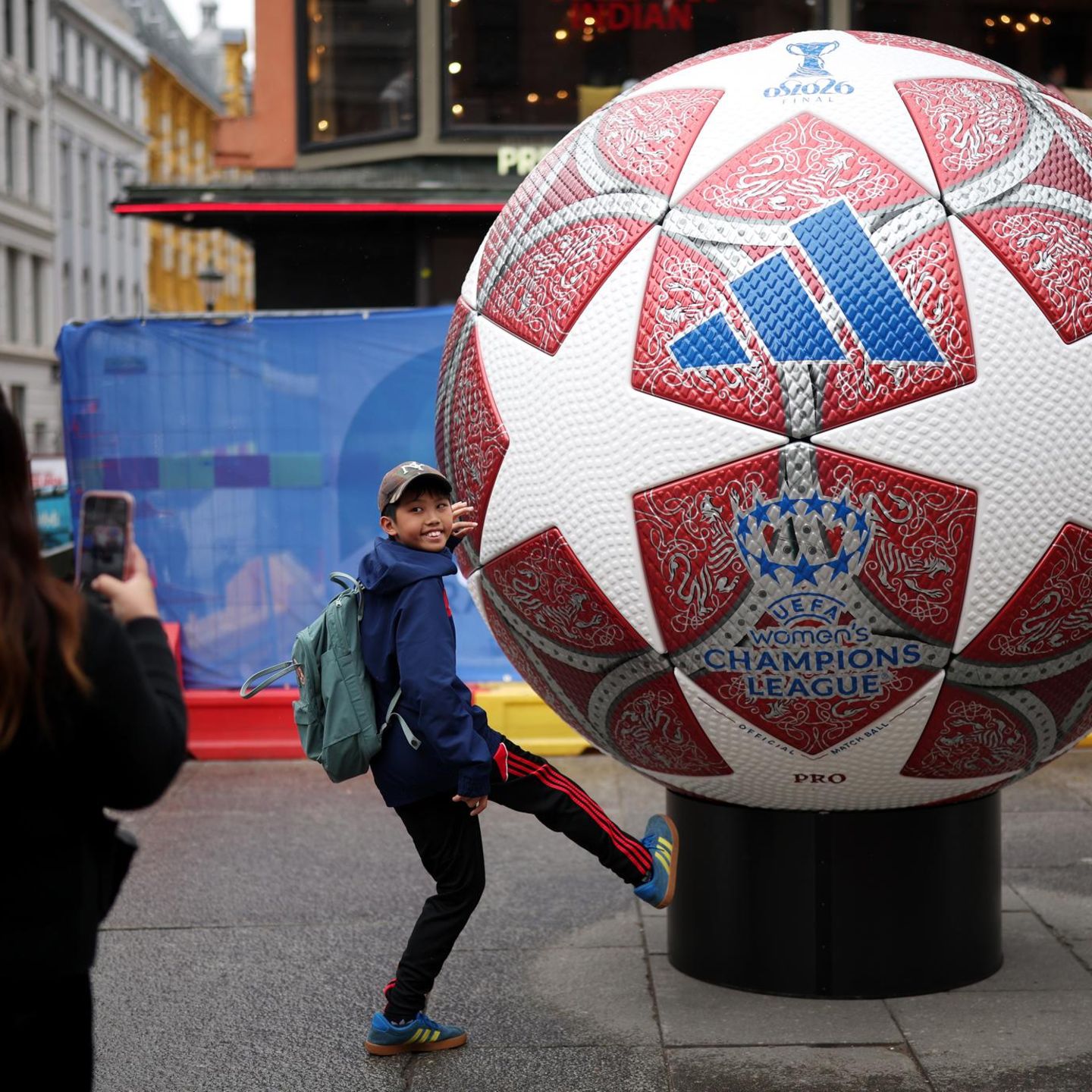 EIn Junge posiert vor einem übergroßen Fußball