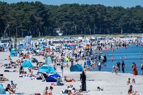 Auch ins Wasser trauten sich die ersten Badegäste. Foto: Stefan Sauer/dpa