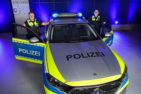 Eine Beamtin und ein Beamter der Polizei Hamburg stehen vor einem Streifenwagen mit dem neuen "Präsenzlicht" Foto: Christian Cha