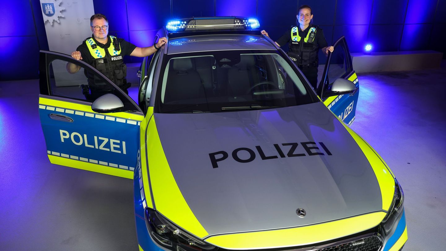 Eine Beamtin und ein Beamter der Polizei Hamburg stehen vor einem Streifenwagen mit dem neuen "Präsenzlicht" Foto: Christian Cha