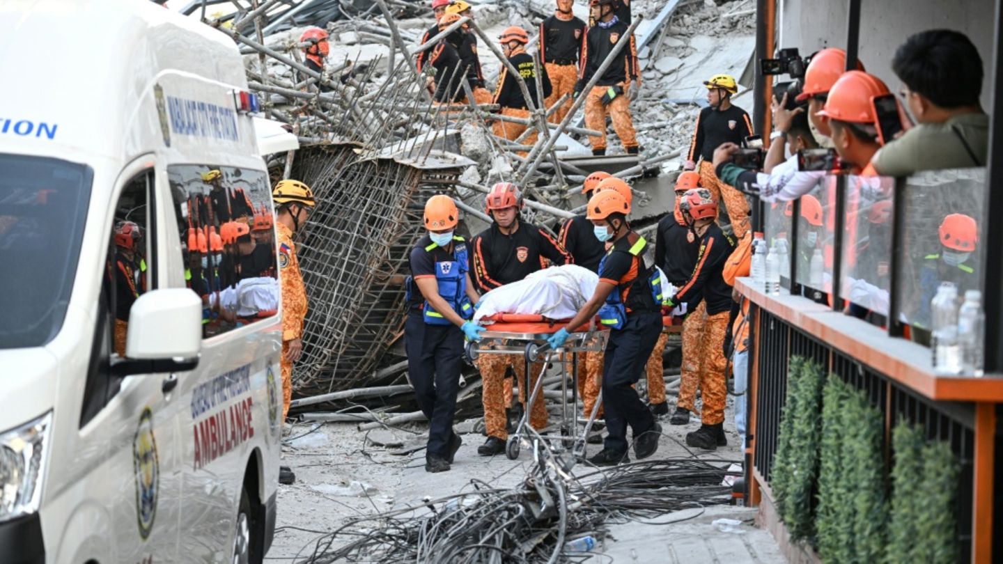 Rettungskräfte bergen einen Toten aus dem Trümmerberg