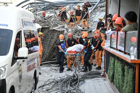 Rettungskräfte bergen einen Toten aus dem Trümmerberg