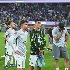 Die Spieler des VfL Wolfsburg stehen nach dem Abstieg mit betretenen Mienen auf dem Rasen