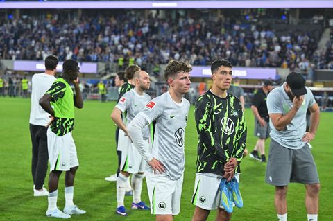 Die Spieler des VfL Wolfsburg stehen nach dem Abstieg mit betretenen Mienen auf dem Rasen