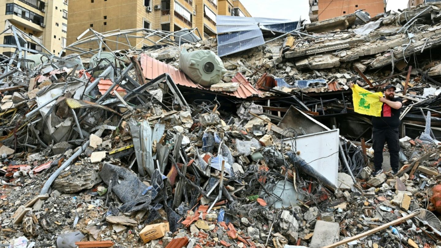 Mann mit Hisbollah-Fahne auf Trümmern in Beirut