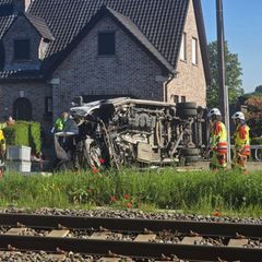 In Buggenhout, Belgien, liegt ein zerstörter Schulbus neben Bahngleisen auf der Seite