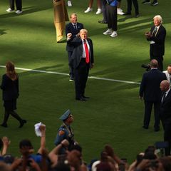 Donald Trump steht auf einem Fußball-Spielfeld