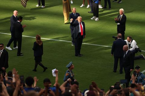 Donald Trump steht auf einem Fußball-Spielfeld