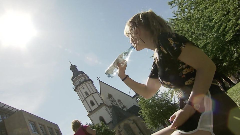 Eine Frau trinkt aus einer Wasserflasche.