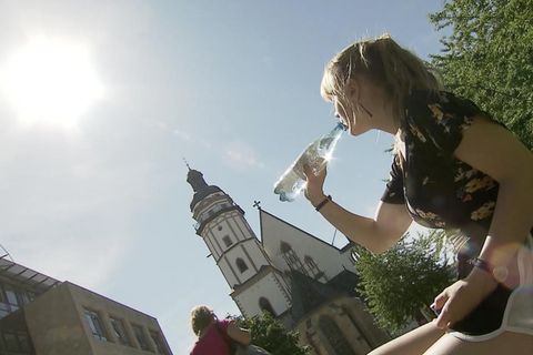Eine Frau trinkt aus einer Wasserflasche.
