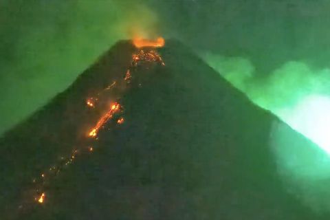 Ein Meteor zieht an einem aktiven Vulkan vorbei.