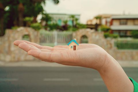 Hauskauf: Hand mit Miniaturhaus