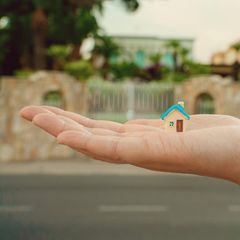 Hauskauf: Hand mit Miniaturhaus